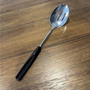 Vintage Ekco stainless steel slotted spoon with black handle